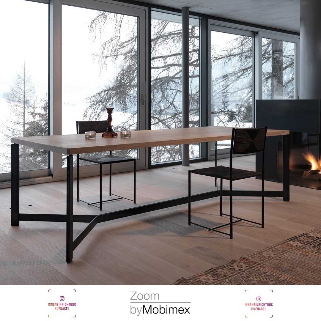 | Zoom by Mobimex DB11 design by Dante BonucelliDie massive Holztafel wird durch das metallene Untergestell getragen. Sichtbare Verschraubungen verbinden die vertikalen Doppelprofile des Fusses mit der Montageplatte und dem unteren Fußabschluss. Di